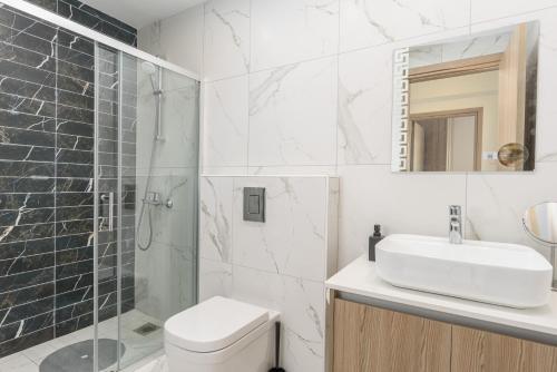 a bathroom with a toilet and a sink and a shower at Mirage 2-BR Apartment in Larnaca in Larnaca