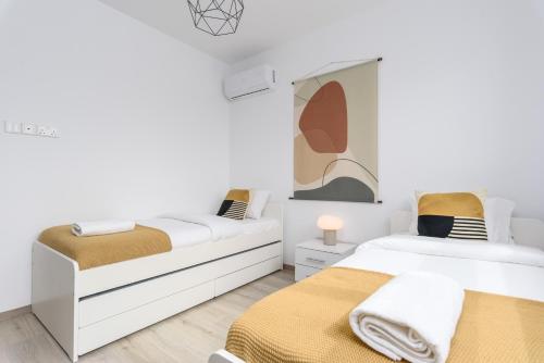 two beds in a room with white walls at Mirage 2-BR Apartment in Larnaca in Larnaca