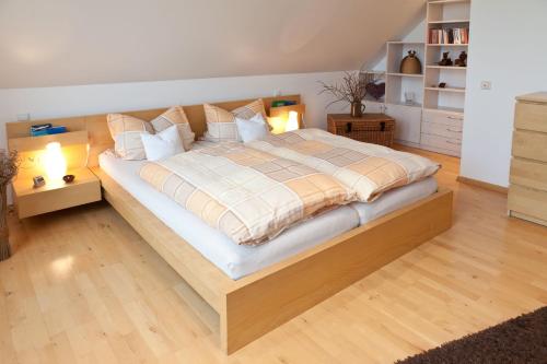 Un dormitorio con una cama grande con almohadas. en Luxus-Idyll mit Pfalz-Panorama, en Rhodt unter Rietburg