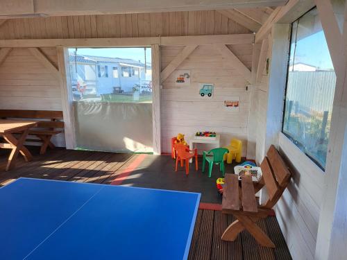 vistas a una sala de juegos con mesa y sillas en Domki GAMA en Gąski