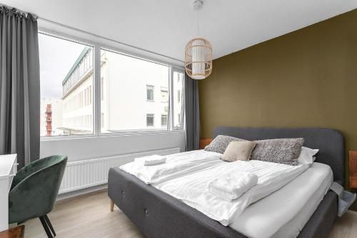 a bedroom with a bed and a large window at Modern Apartment in Kópavogur in Reykjavík
