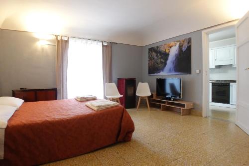 een hotelkamer met een bed en een televisie bij Exclusive Apartments in center in Mistretta