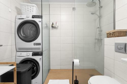 Modern Apartment in Kópavogur في ريكيافيك: وجود غسالة في الحمام مع دش