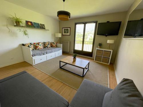 uma sala de estar com um sofá e uma mesa em Studio au pied du Vercors em Saint-Jean-en-Royans