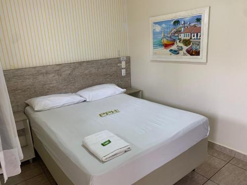 a bed with two towels on it in a room at Pissin Plaza Hotel in Goiânia