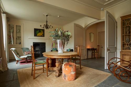 a dining room with a table with a vase of flowers at Victorian House in Grasmere