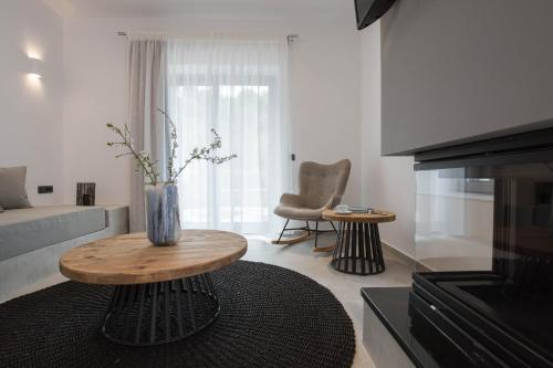 a living room with a table with a vase on it at Evge Experience Boutique Hotel in Kafoúros
