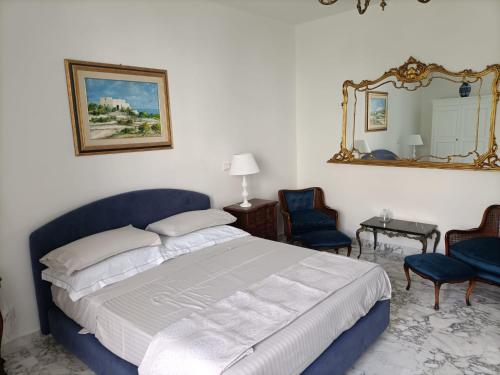 een slaapkamer met een bed, een spiegel en stoelen bij Il Giardino della Scuncerta in Lecce