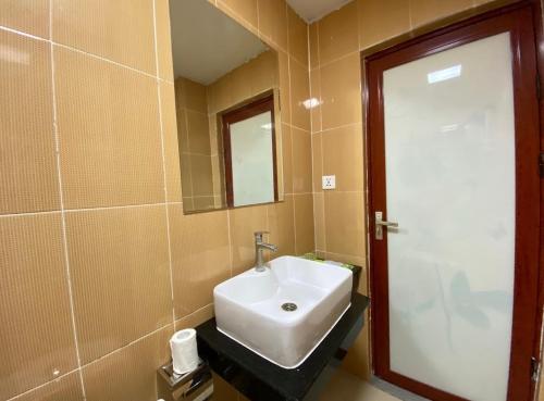 a bathroom with a white sink and a mirror at Yaou Hotel in Phnom Penh