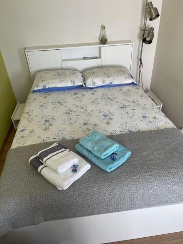 uma cama com duas toalhas e duas almofadas em Mājīgs studio apartaments jūras pilsētā em Ventspils