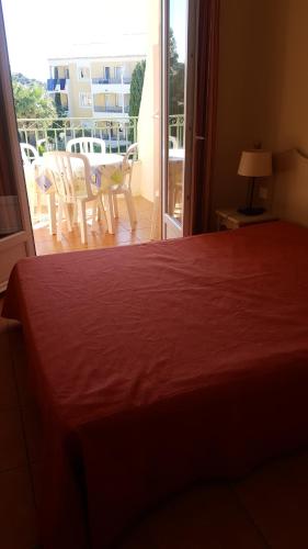 une chambre avec un lit et une vue sur un balcon dans l'établissement CHARMANT APPARTEMENT T2 VUE SUR PISCINE, aux Issambres