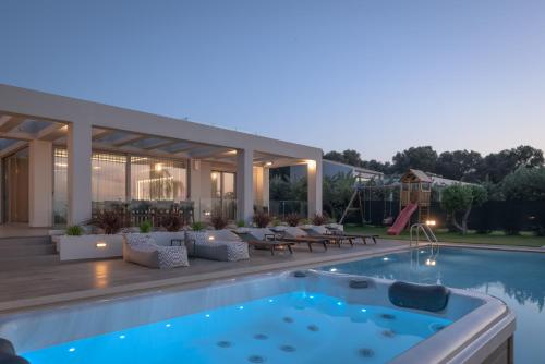 a backyard with a swimming pool and a house at Agrielia Villas, featuring Heated Spa Whirlpool, By ThinkVilla in Pigianos Kampos