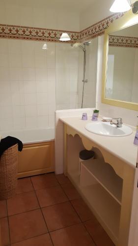 une salle de bain avec un lavabo, une baignoire et un miroir dans l'établissement CHARMANT APPARTEMENT T2 VUE SUR PISCINE, aux Issambres
