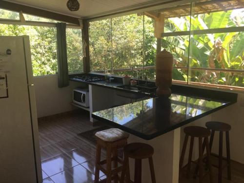 a kitchen with a counter and stools in a room at Casa especial em Itacaré in Itacaré