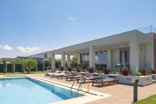 a view of a building with a swimming pool at Agrielia Villas, featuring Heated Spa Whirlpool, By ThinkVilla in Pigianos Kampos