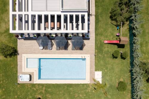 einen Blick über einen Pool im Hof in der Unterkunft Agrielia Villas, featuring Heated Spa Whirlpool, By ThinkVilla in Pigianos Kampos