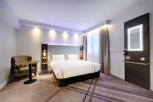 - une chambre avec un lit, un bureau et une chaise dans l'établissement Premier Inn Berlin City Wilmersdorf, à Berlin