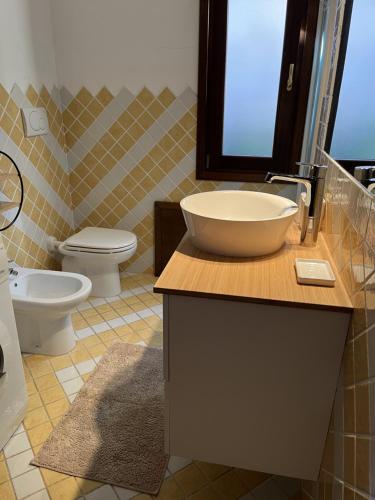 a bathroom with a sink and a toilet at Costa Paradiso House in Li Valcaggi