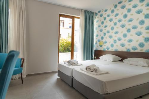 ein Schlafzimmer mit einem Bett mit zwei Handtüchern darauf in der Unterkunft Ema Hotel in Sozopol