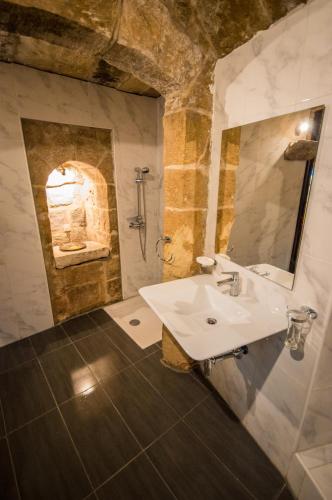 a bathroom with a sink and a shower at The Burrow Guest House in Tarxien