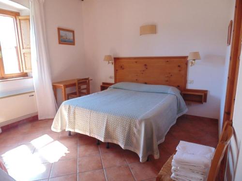 1 dormitorio con 1 cama con cabecero de madera en LaSelva, en Albinia