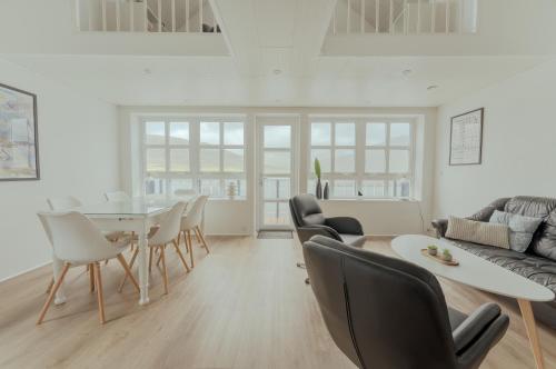een woonkamer met een tafel en stoelen bij Dahlastova / Stunning Boathouse / Bay View / 3BR in Hvalvík