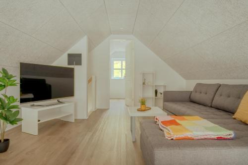 a living room with a couch and a flat screen tv at Dahlastova / Stunning Boathouse / Bay View / 3BR in Hvalvík