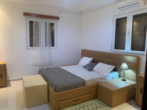 a bedroom with a bed and two windows at Ubá Budo Praia - Villa in São Tomé