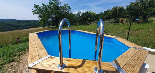 - une piscine avec une terrasse en bois et 2 poignées en métal dans l'établissement Maison en Périgord, à Plazac