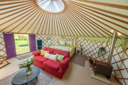 a living room with a red couch in a yurt at Luxury glamping in Constable Country - Valley View Yurt 
