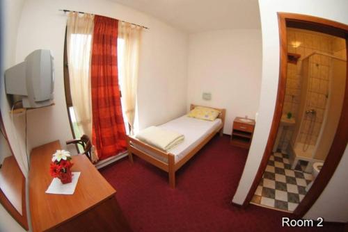 a small bedroom with a bed and a mirror at Motel Bella Italia in Sarajevo