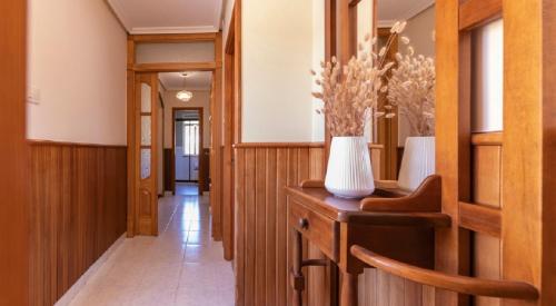 a hallway with wood paneling and a vase at Casa Bértolo in Morás