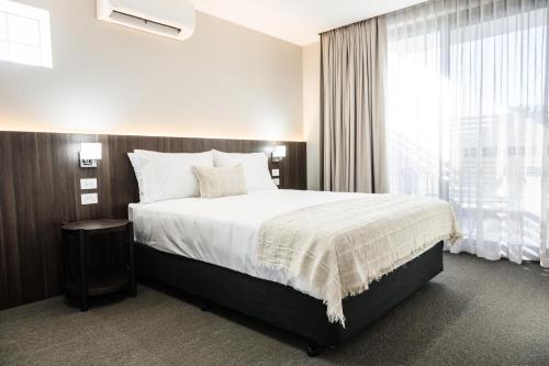 Un dormitorio con una cama grande y una ventana en 107 George en Kalbar