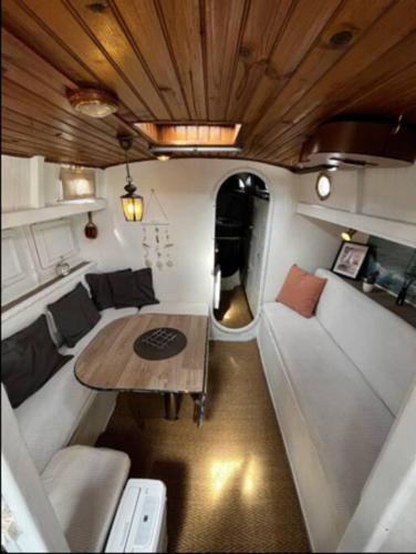 a living room with a table and a couch in a trailer at Bateau Watson, vivez l'aventure in Ouistreham