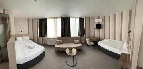 a large hotel room with two beds and a couch at Bistra & Galina Hotel in Ruse