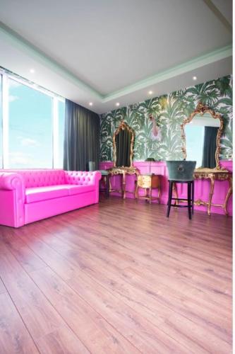 a living room with a pink couch and chairs at The Shankly Hotel in Liverpool