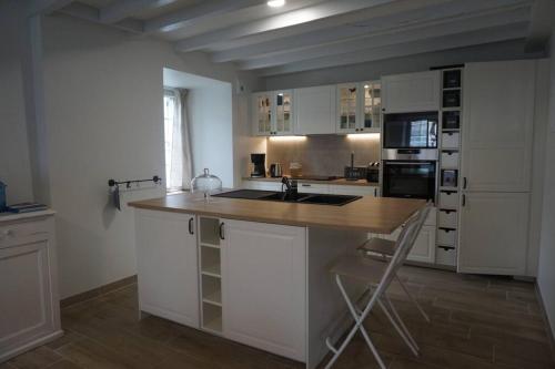 une cuisine avec des armoires blanches et un comptoir en bois dans l'établissement Le clos du 10, à Treignac