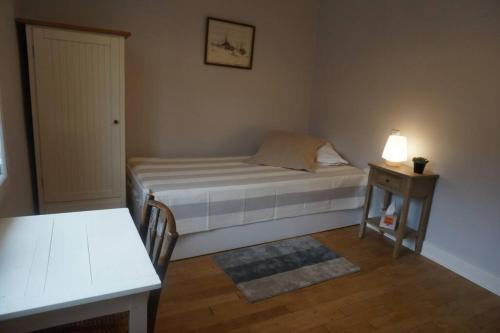 um pequeno quarto com uma cama e uma mesa em Le clos du 10 em Treignac