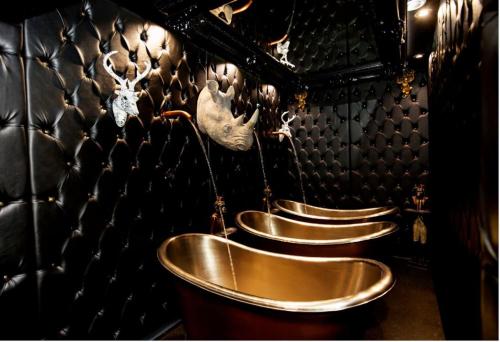 a row of five gold urinals in a room at The Shankly Hotel in Liverpool