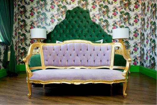 a purple couch in a room with floral wallpaper at The Shankly Hotel in Liverpool