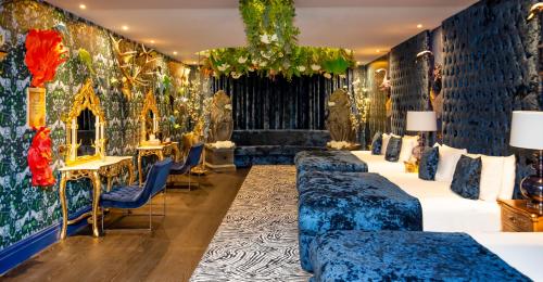 a room with blue couches and a wall covered in wallpaper at The Shankly Hotel in Liverpool