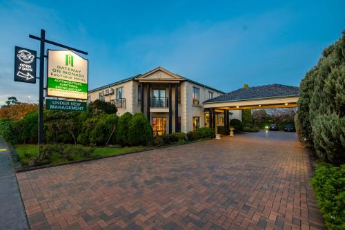 a building with a sign next to a brick driveway at Gateway on Monash in Clayton North