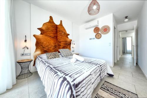 Schlafzimmer mit einem Bett mit einem großen Kopfteil aus Holz in der Unterkunft Pachamama House - Near the beach, Air-Con, Fast Wifi and SAT tv By Lanzarote Vacation Homes in Playa Blanca