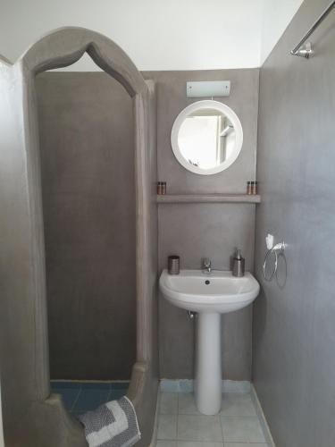 a bathroom with a sink and a mirror at Elzahed apartments orza in Kimolos