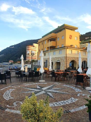 a patio with tables and chairs and a building at Chiavari Beach in Chiavari