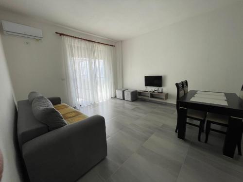 een woonkamer met een bank en een eettafel bij Jurgen's Apartaments in Vlorë