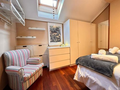 1 dormitorio con 1 cama, 1 silla y 1 ventana en Apartamento El Rey, en Colombres