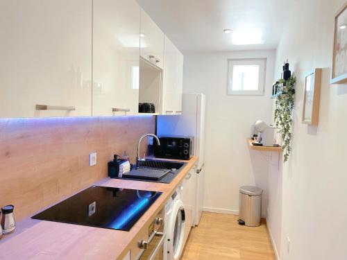 une cuisine avec un évier et un plan de travail dans l'établissement L'intemporel - Grand T2 Climatisé, Terrasse couverte en Hypercentre, à Castres