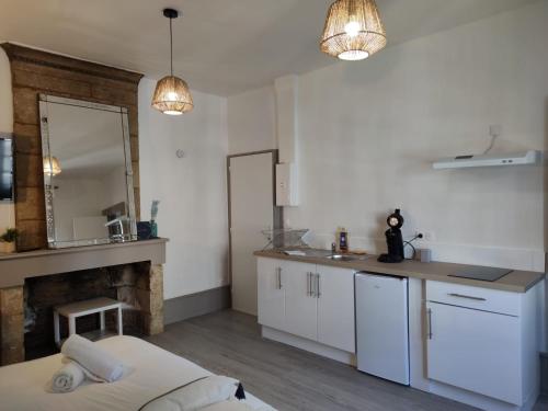 - une cuisine avec un lit, un évier et un comptoir dans l'établissement *LES STUDIOS L'AMANDINE*, à Périgueux