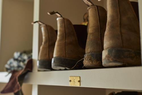 a row of brown boots sitting on a shelf at Victorian House in Grasmere